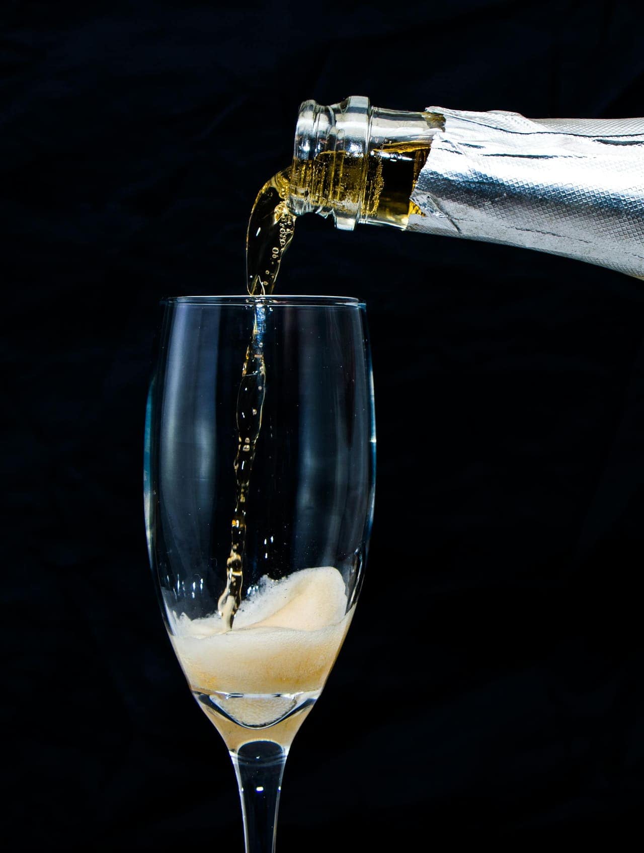 Geschonken glas champagne in een warm belichte tafelsetting