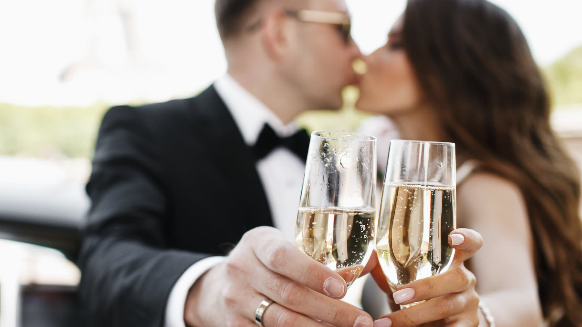 Bruidspaar kust met champagneglazen voor retro auto in Parijs